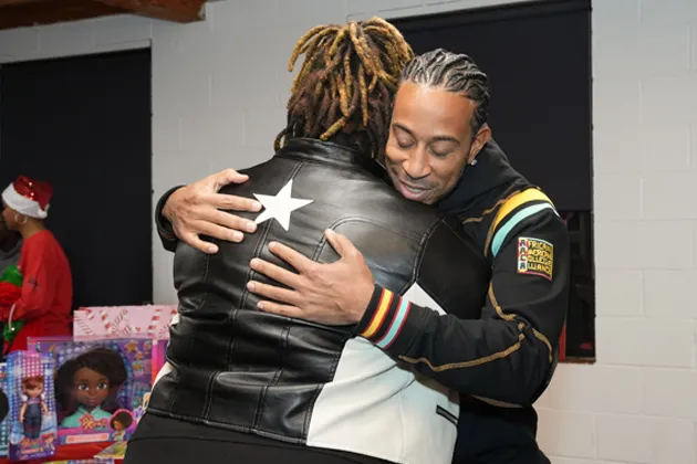 Ludacris poses with a child at the Empowerment Brunch event.